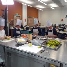 children being taught how to cook